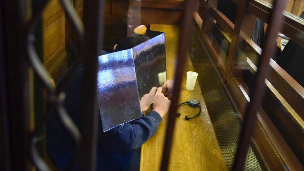 Alleged Islamic State jihadist Shaas al-M hides his face as he waits for the opening of his trial on 4 January 2017 in Berlin