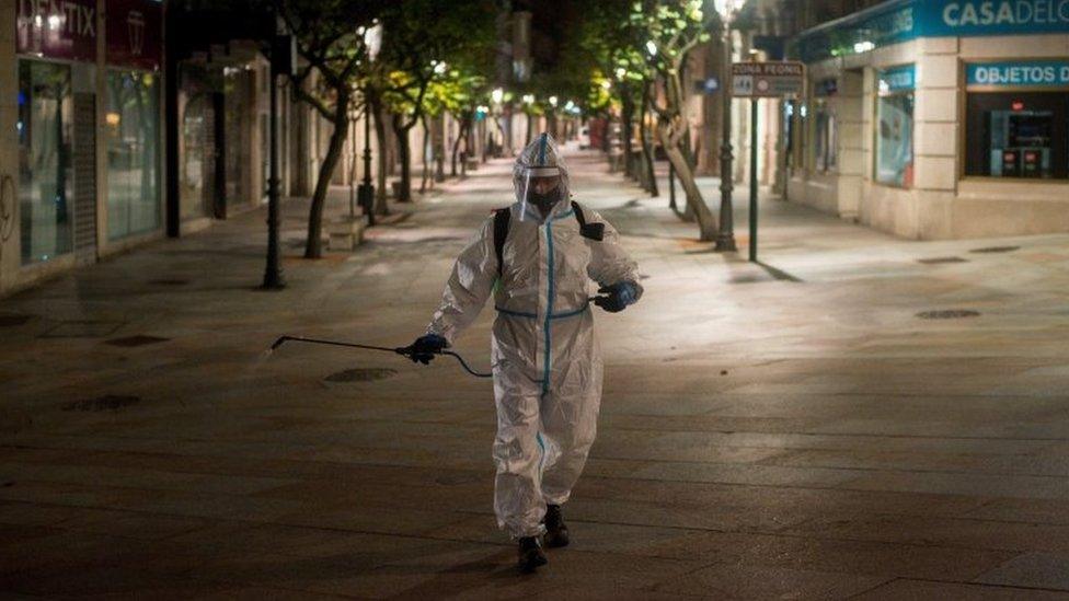 A local cleaner disinfects parts of Barcelona