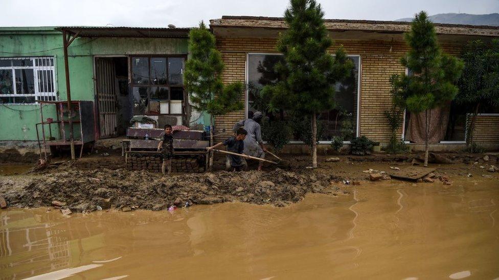 Villagers use shovels to clear the mud on the roadside after flash floods killed at least 162 people in Afghanistan in August 2020 (file picture).