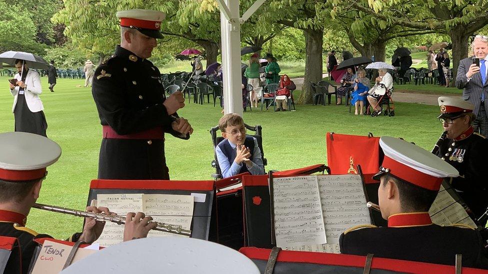 Tobias listens to band at garden party