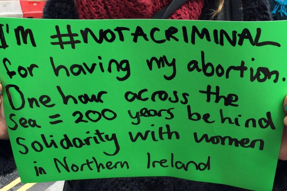 Placard reading: "I'm #notacriminal for having my abortion. One hour across the sea = 200 years behind. Solidarity with women in Northern Ireland."