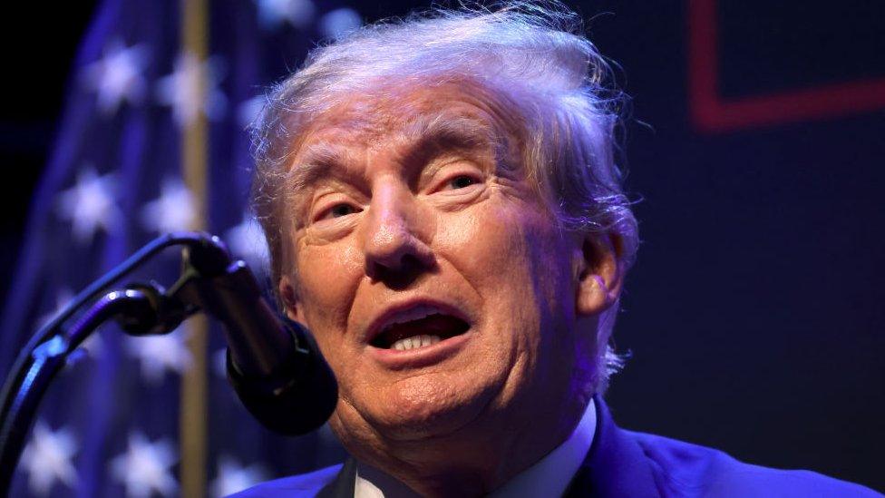 Former President Donald Trump speaks into mic at an event at the Adler Theatre on 13 March 2023 in Davenport, Iowa