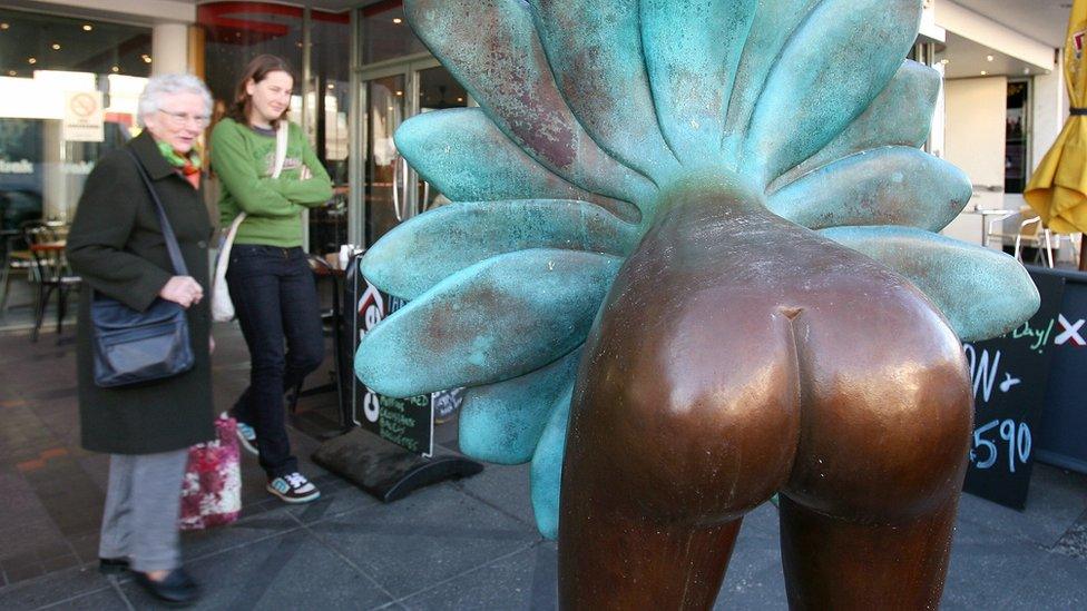 Two passers-by inspect a bronze sculpture in the Melbourne suburb of Toorak