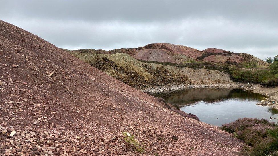 old copper mine at Parys Mountain on Anglesey, with spoil heaps stained different colours by the metal ores in the rocks