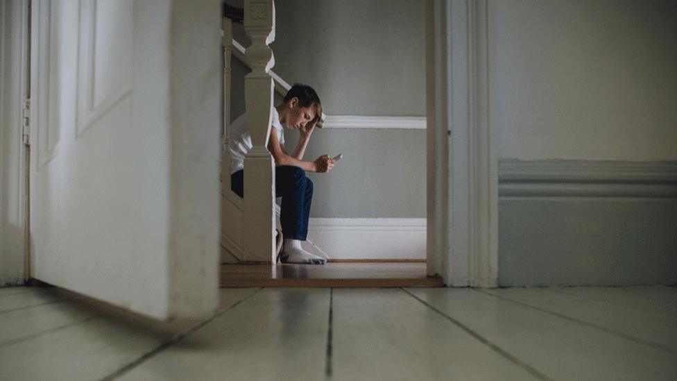 Boy on stairs with phone