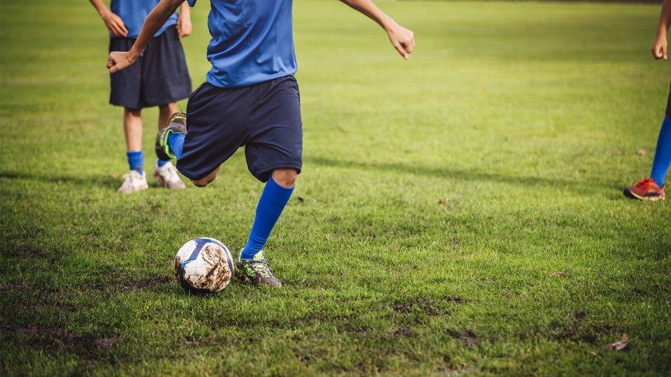 A boy kicking a football