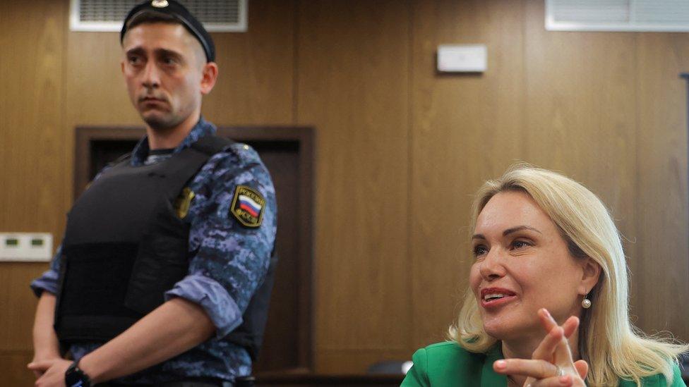 Former Russian state TV employee Marina Ovsyannikova attends a court hearing in Moscow, flanked by a guard