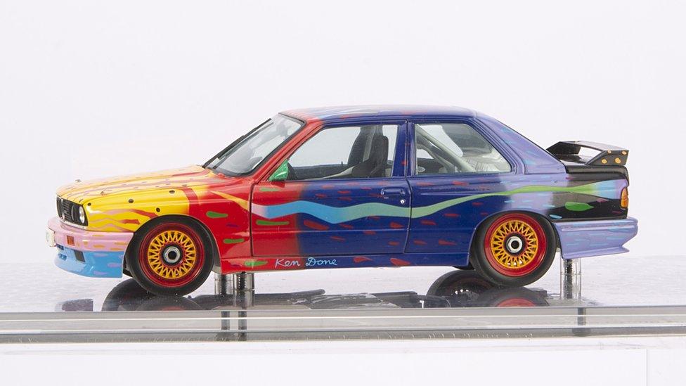 a yellow, red and blue model car with red and yellow wheels