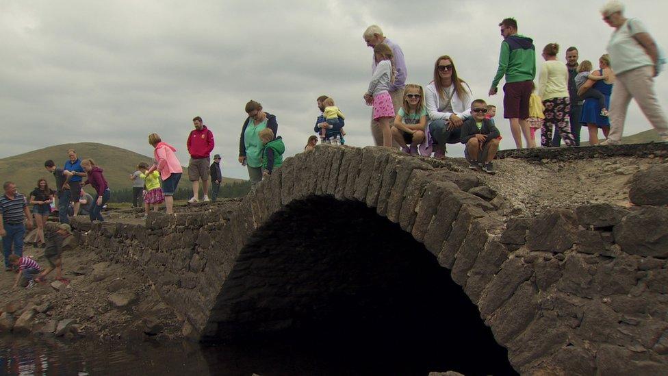 People walking across the bridge at Spelga Reservoir