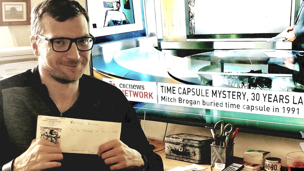 Mitch Brogan holding up the time capsule envelope