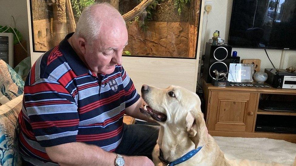 Alex Gosney at home talking to his guide dog Homer