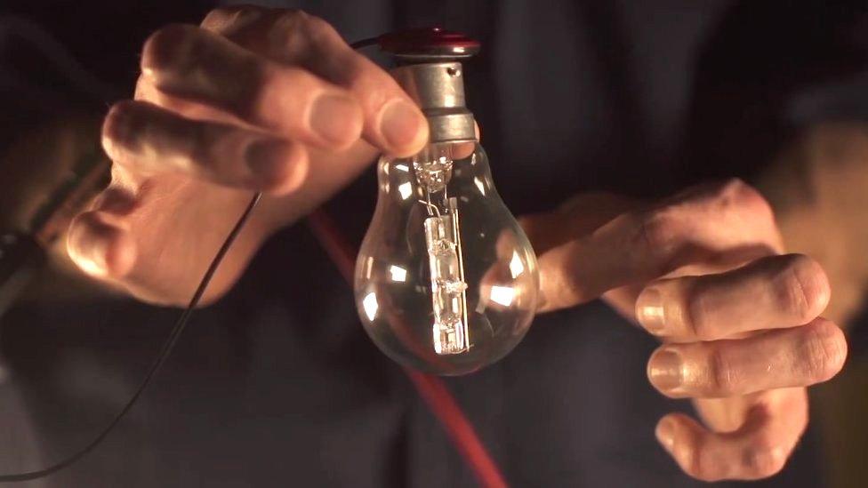 Man flicking a light bulb and recording the sound it makes