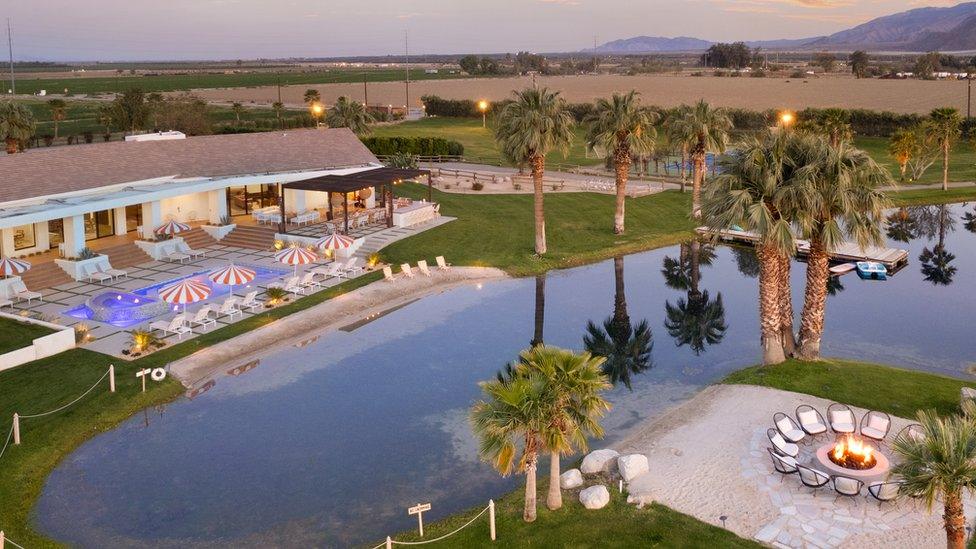 House with pool and palm trees and lake