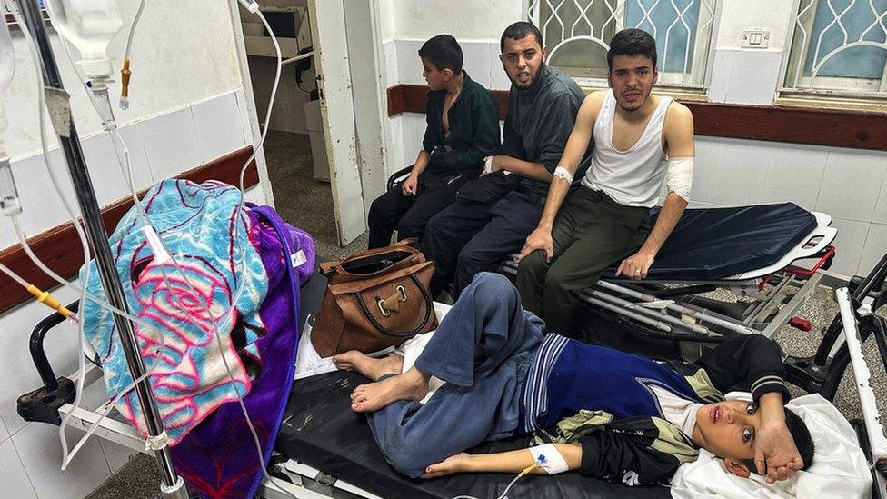 A Palestinian boy, who is diagnosed with gastroenteritis, lies on a bed as he receives treatment at a hospital in Rafah, in the southern Gaza Strip (12 December 2023)