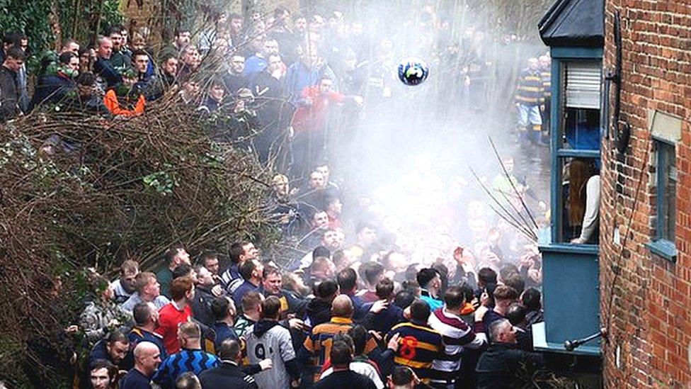 Players from the Up'ards and Down'ards teams compete for the ball in the Henmore Brook Derbyshire.