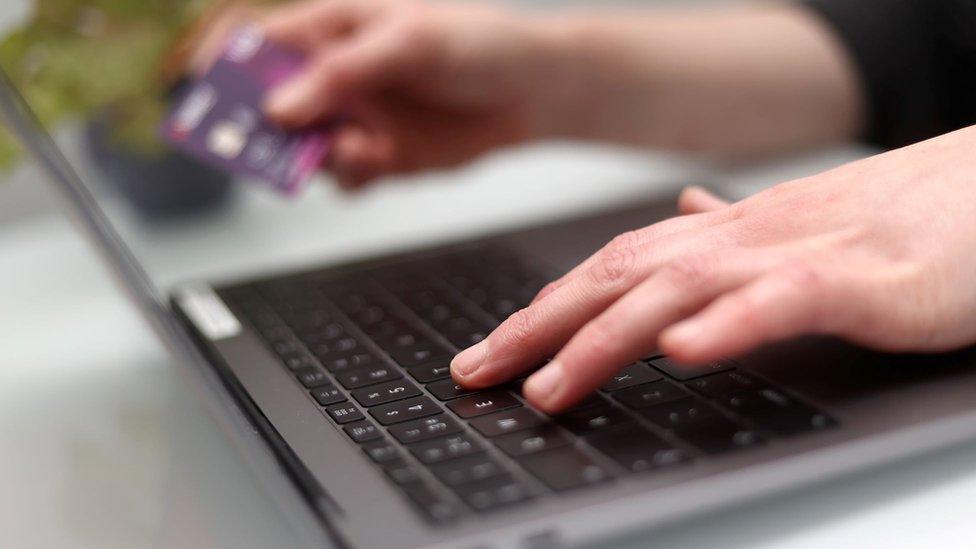 Picture shows a laptop of a white pair of hands typing on a laptop keyboard