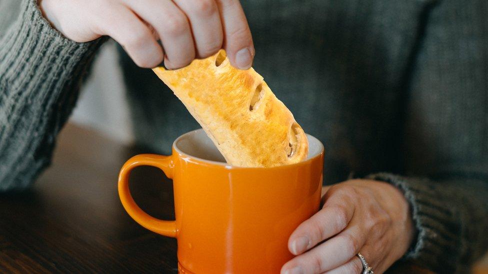 Dunking a sausage roll into a cup of tea