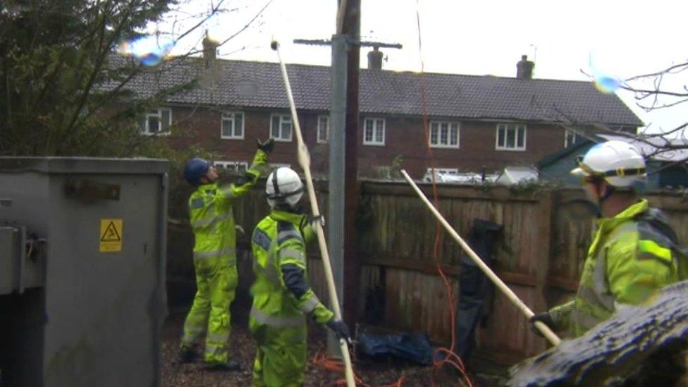 Three workers in high-vis jackets near a power line