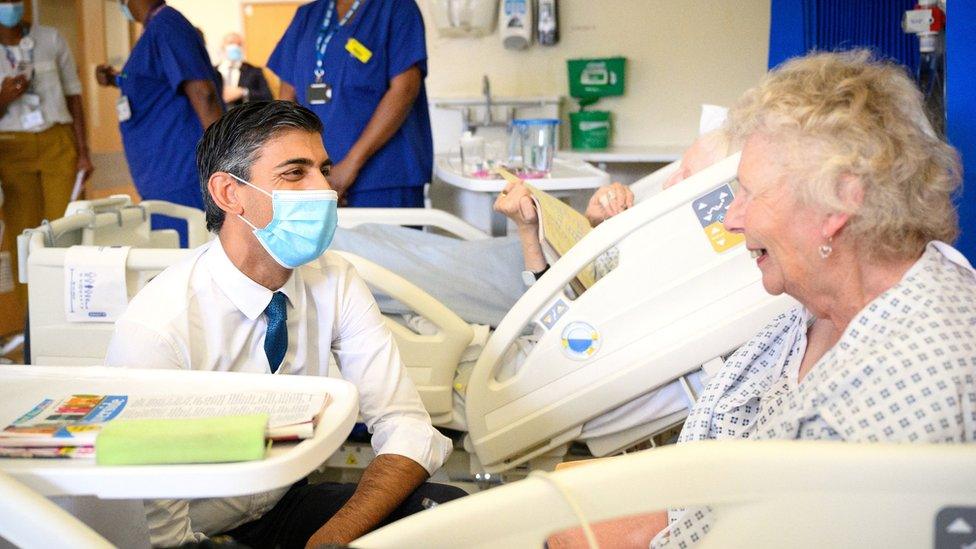 Prime Minister Rishi Sunak speaks with patient Catherine Poole as he visits Croydon University Hospital