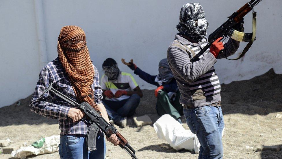 Armed Kurdish militants of the Kurdistan Workers" Party (PKK) stand behind a barricade during clashes with Turkish forces on September 28, 2015, at Bismil, in Diyarbakir