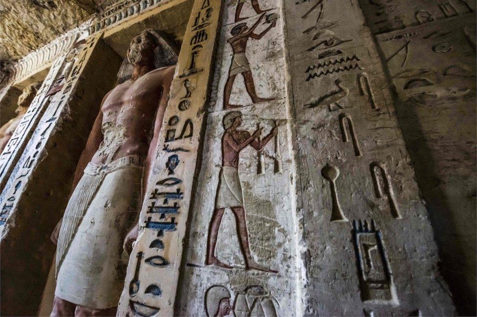 Coloured statues and hieroglyphs inside the tomb at Saqqara