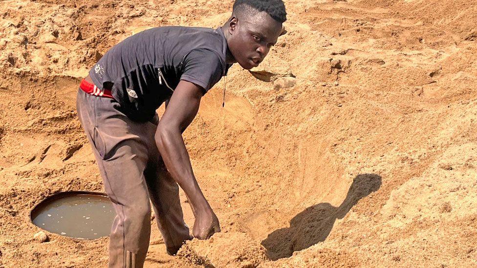 A man digs for water in a riverbed in Kurima village, Zimbabwe