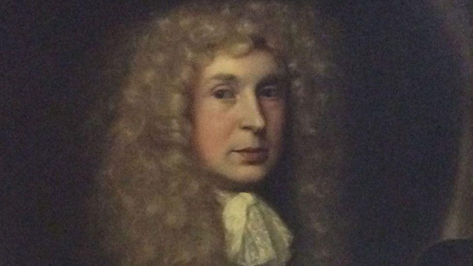 A 17th Century portrait of Sir John Gaudy. He is wearing a long curling wig and is clean shaven. There is lace around his neck.
