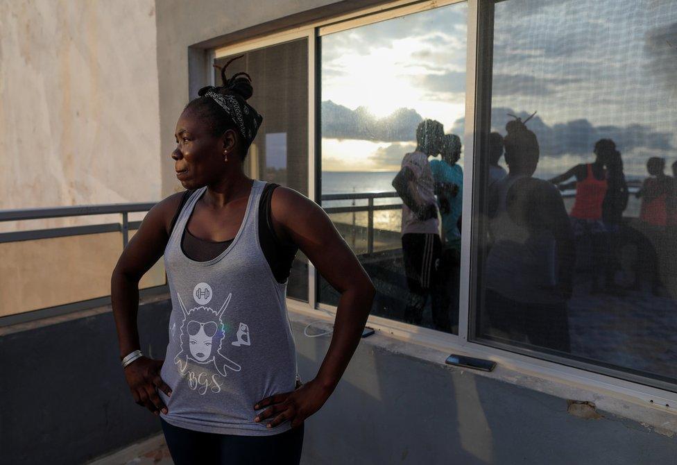 Khadjou Sambe stands on a patio and looks out to sea