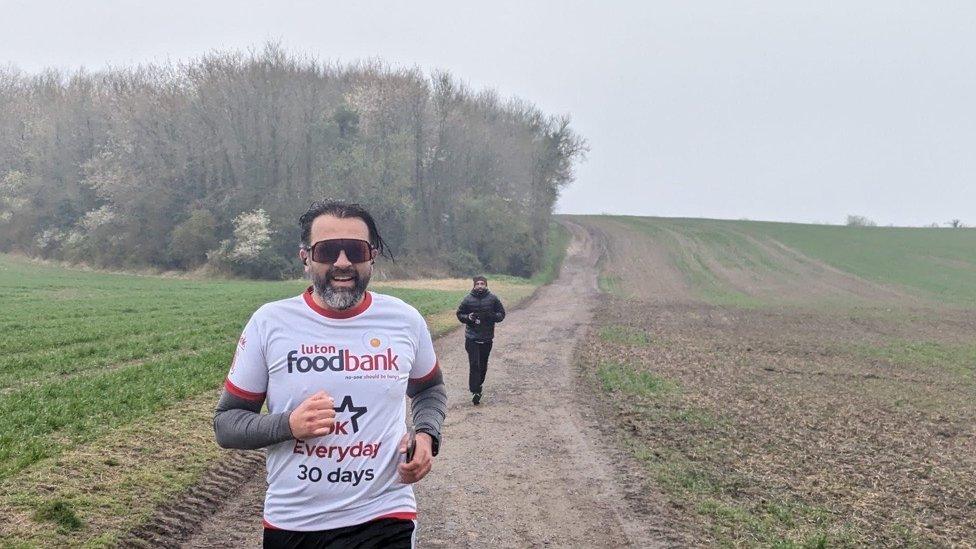 Bilal Hussain running along a path through fields