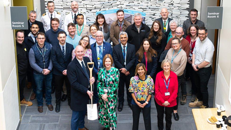 Hospital staff at the launch of the construction at the hospital. One man is symbolically holding a spade