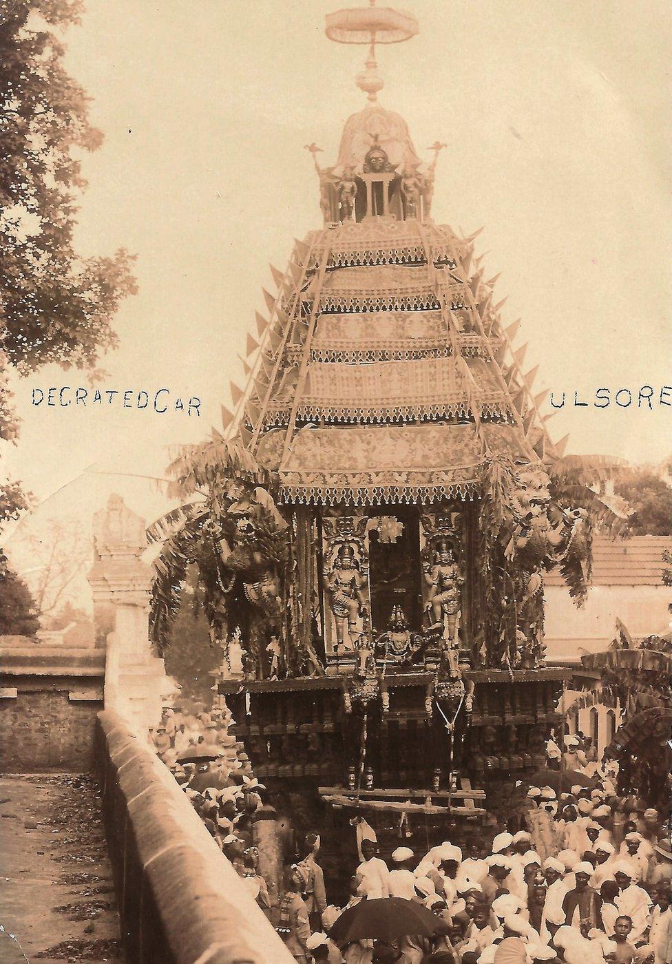 A picture showing the entrance of a Hindu temple and a crowd entering the temple