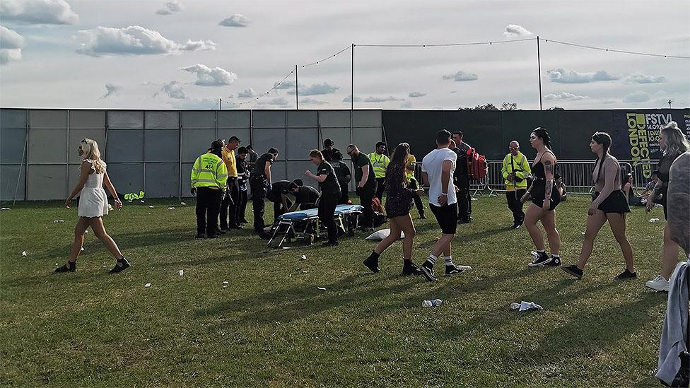 Medical staff help festival goers onto a stretcher