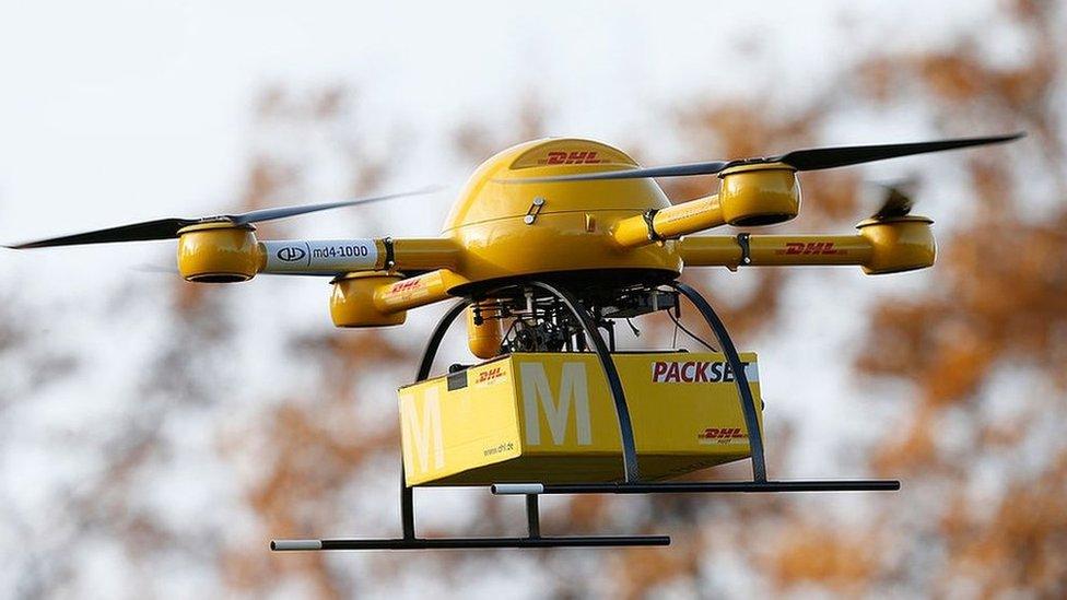 A quadcopter DHL drone arrives with a small delivery at Deutsche Post headquarters in Bonn, Germany: Dec 2013