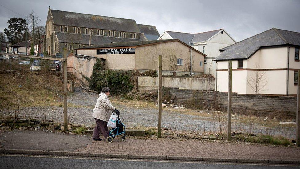 A woman passes a derelict site in Ebbw Vale in Blaenau Gwent, Wales