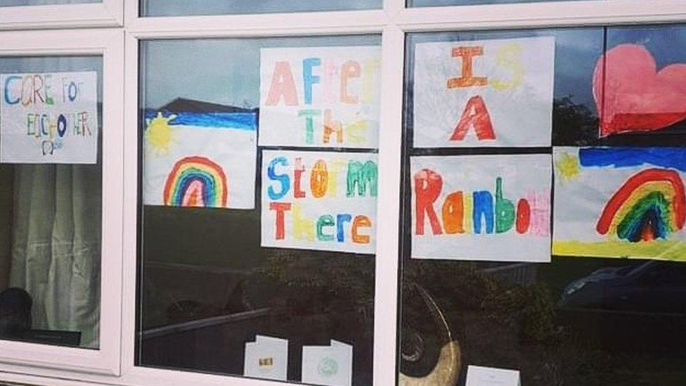 Rainbow posters in house window