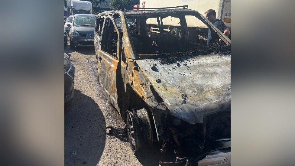 Mobile phone image of the burnt our remains of the van