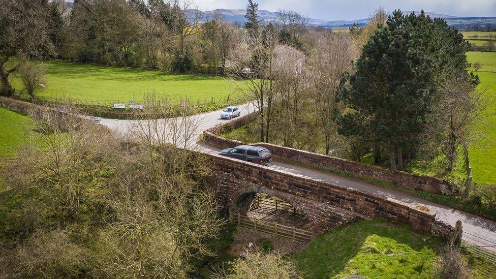 A car drives over the bridge before it was infilled