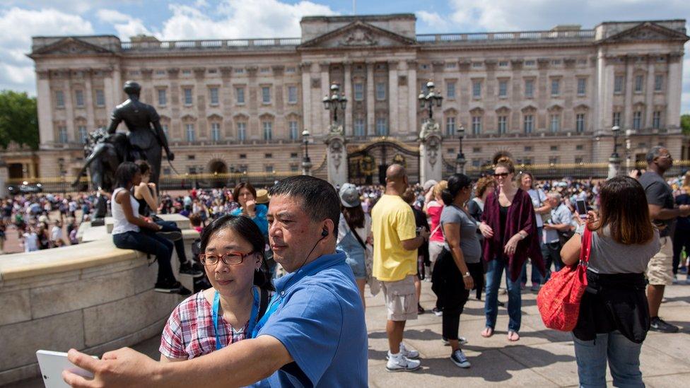 Tourists take a selfie in front of Buckingham Palace