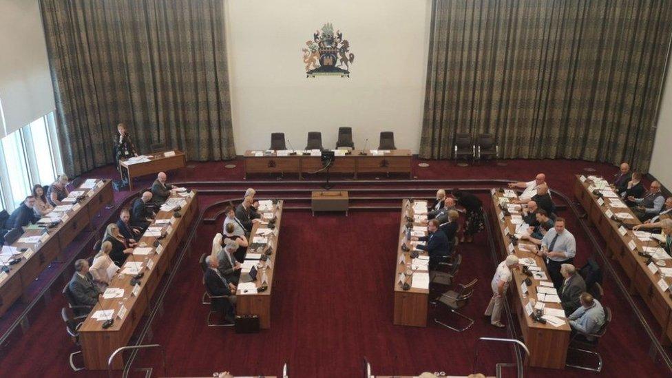 Councillors take part in a meeting in the council chamber