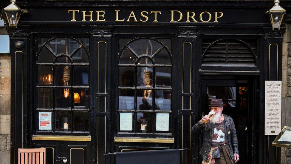 man drinking outside a pub