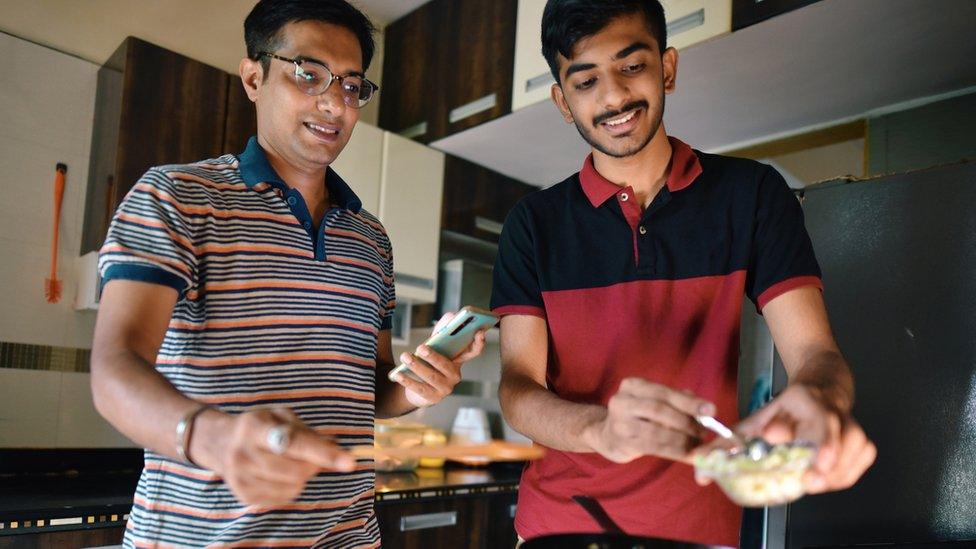 Man teaching teenager to cook