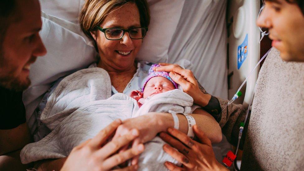 Woman holds newborn baby