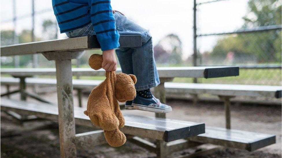 child holding teddy