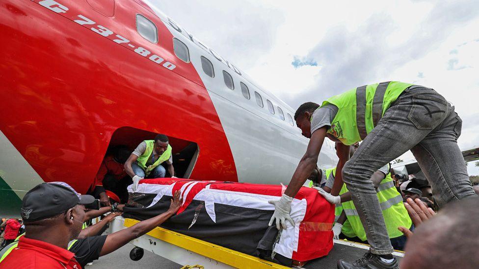 Officials unloading from a plane in Kenya the coffin of Raila Odinga, draped in the Kenyan flag - 16 October 2025