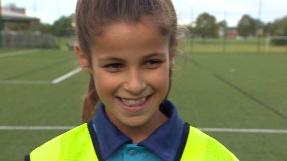 Girl smiling to camera on football field