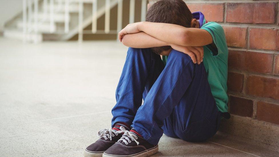 Boy with his head in his hands