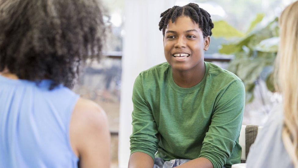 Boy speaking to two women