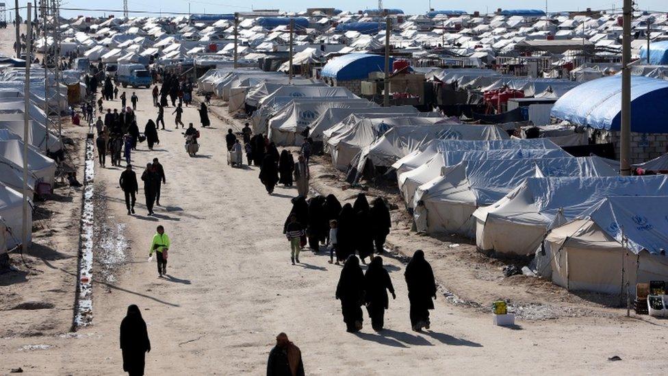 Women walk through al-Hol displacement camp in Hasaka governorate, Syria