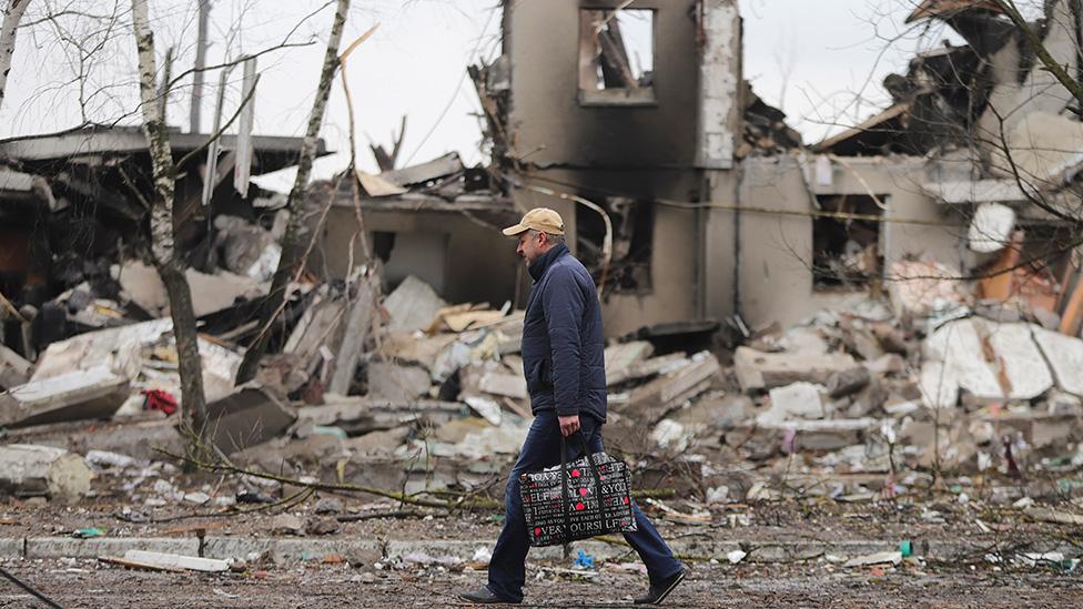 A man goes past burned buildings that were hit by shelling in the small city of Borodyanka near Kiev, Ukraine - 3 March 2022