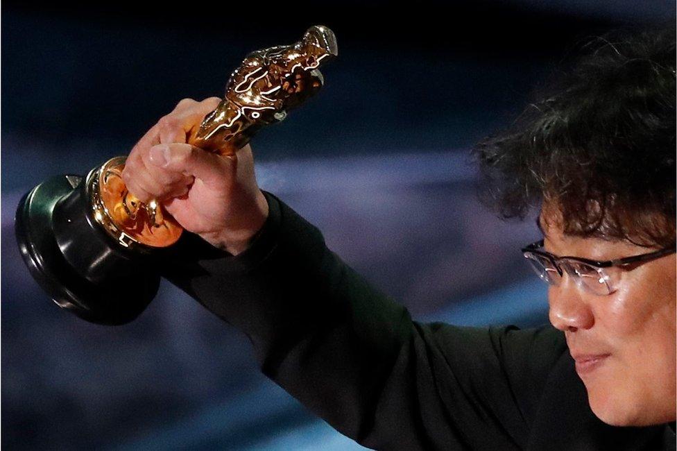 Director Bong Joon Ho holds his Oscar aloft